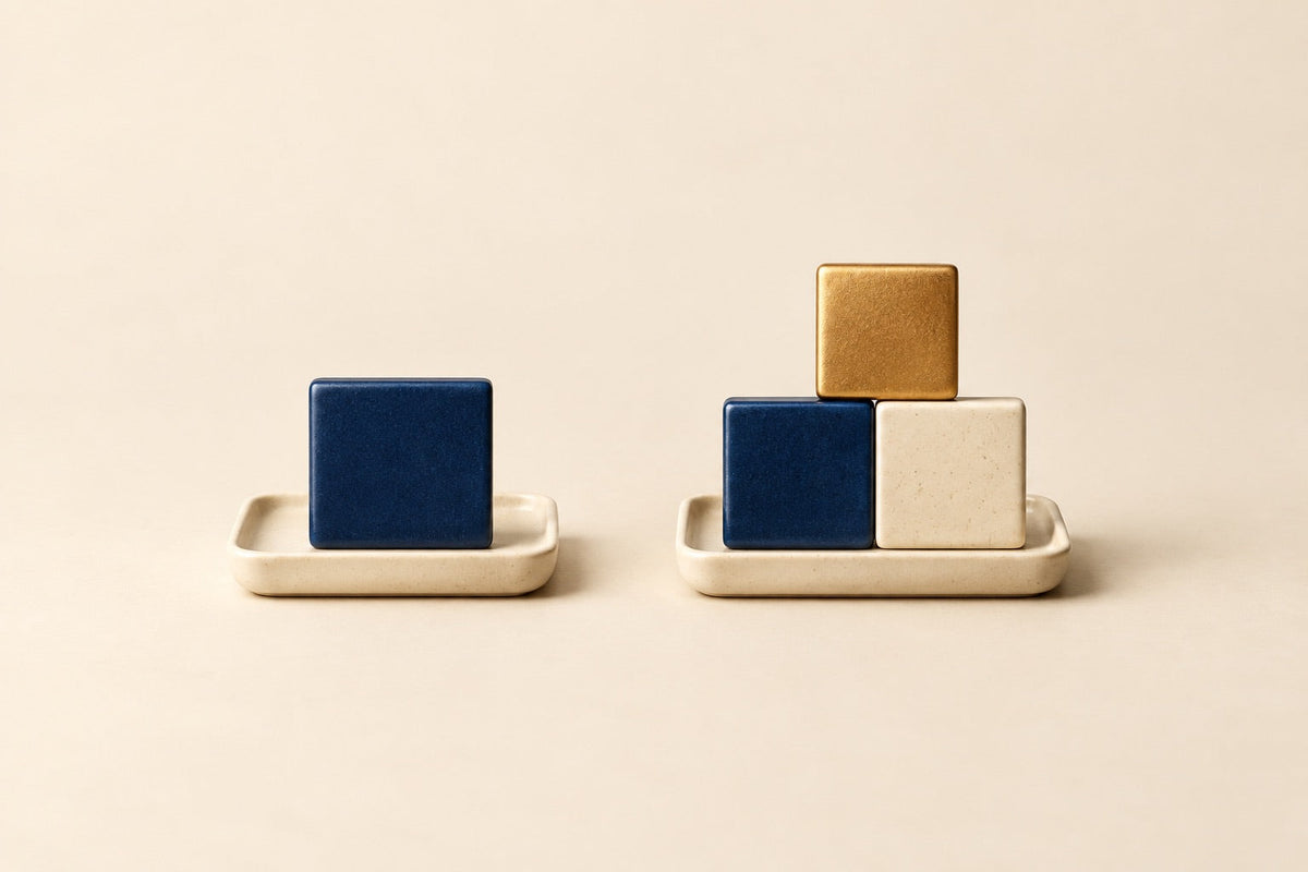 One navy tile and a separate group of three colored tiles form an abstract single-unit versus three-part comparison.