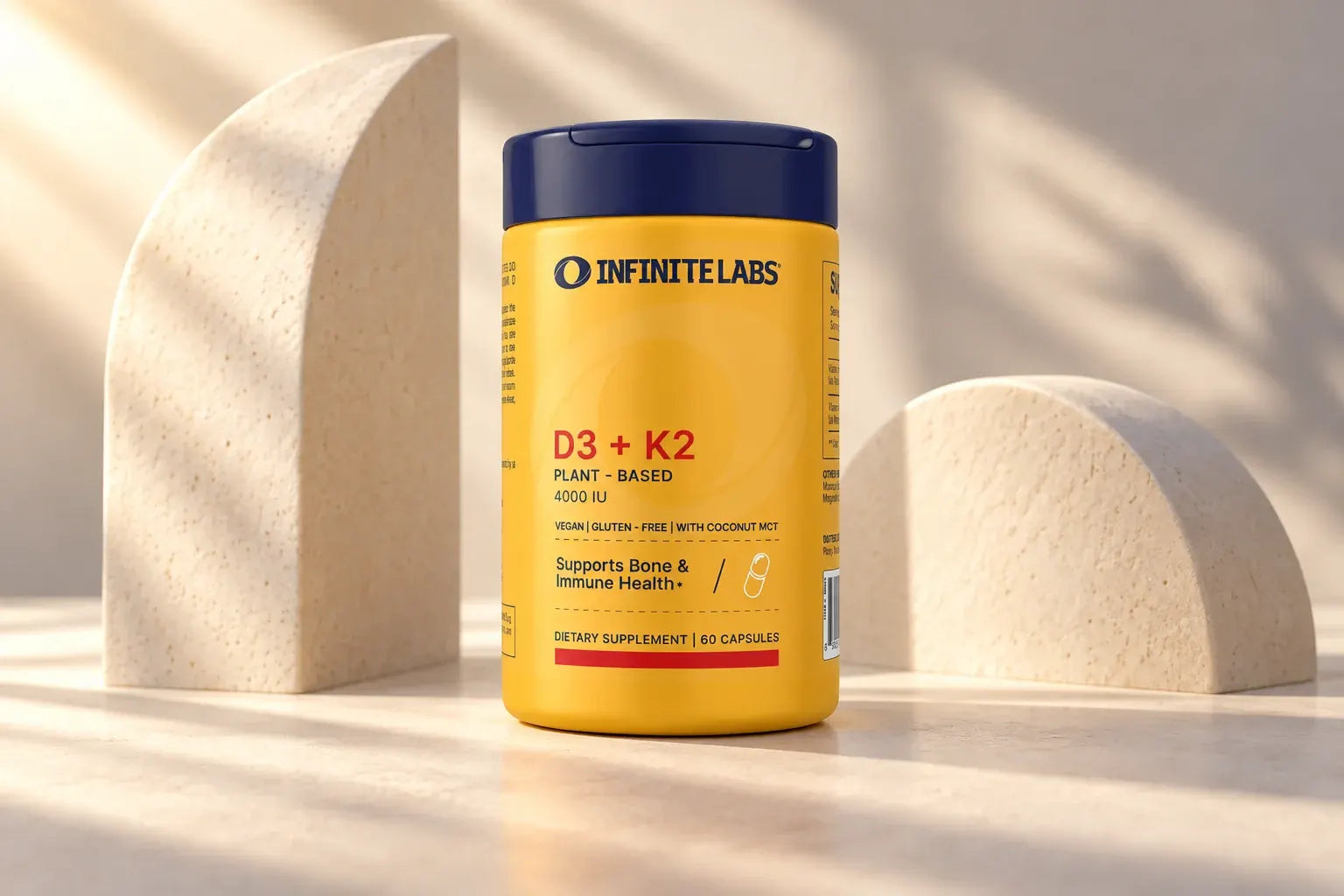 InfiniteLabs D3 + K2 bottle beside two pale sculptural forms.